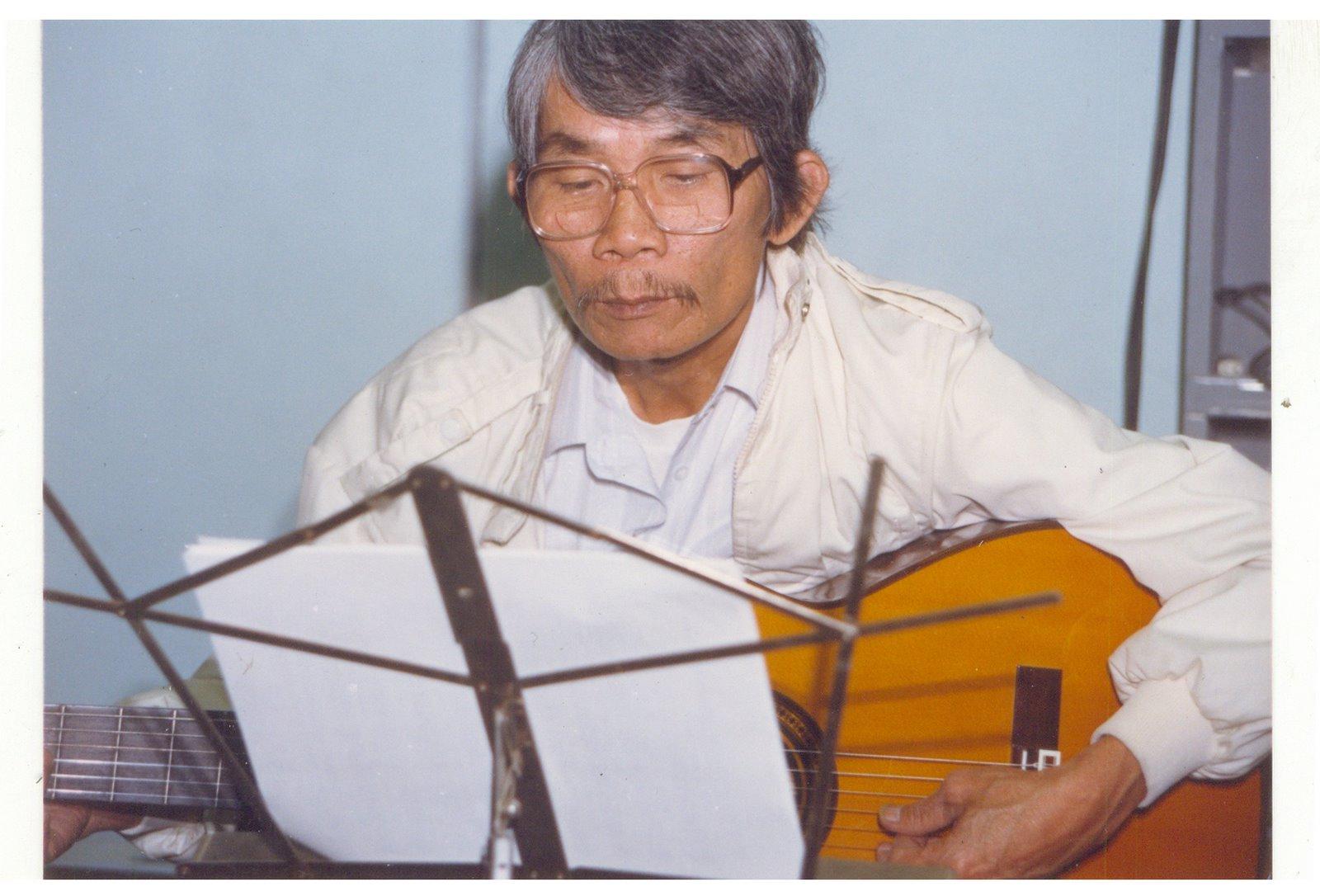 Hình ảnh nhạc sĩ Trầm Tử Thiêng đang chơi ghi ta
