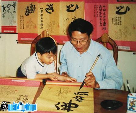 Nhà thơ Nguyễn Vũ Tiềm viết thư pháp và cháu nội