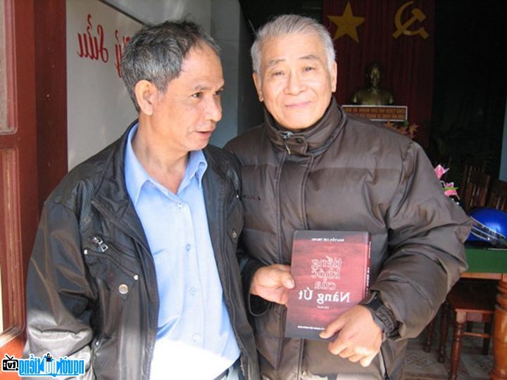 Nhà văn Nguyễn Chí Trung (bên trái) giao lưu và tặng bạn đọc tiểu thuyết Tiếng khóc của nàng Út