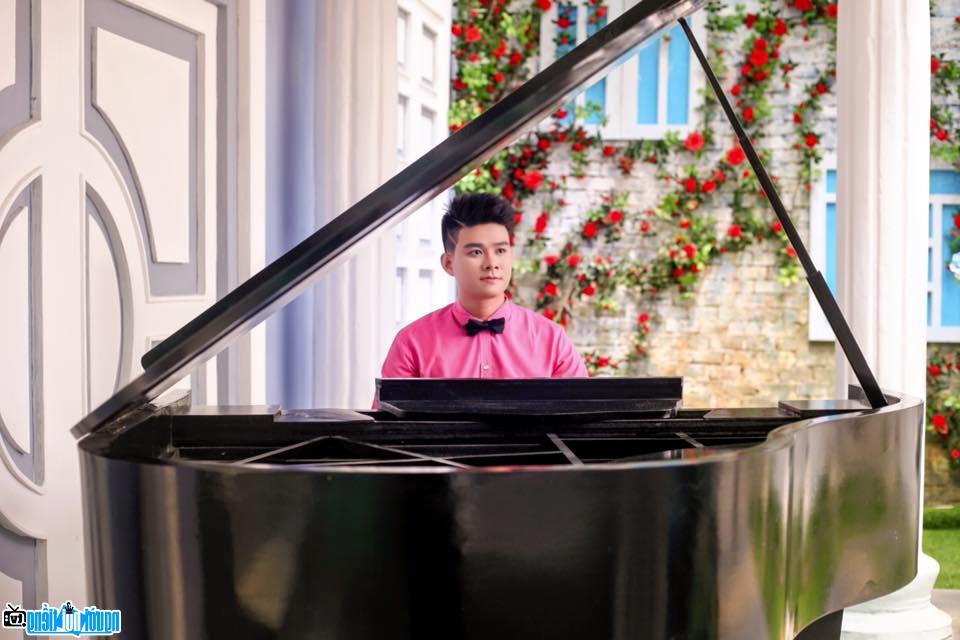 Hình ảnh ca sĩ Lâm Quang Long bên piano