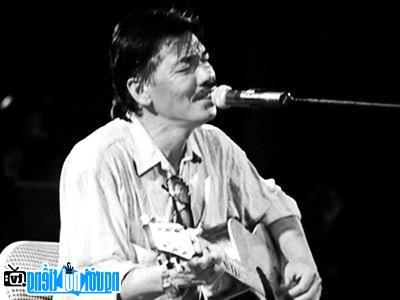 Musician Tran Tien plays guitar and sings on stage by himself