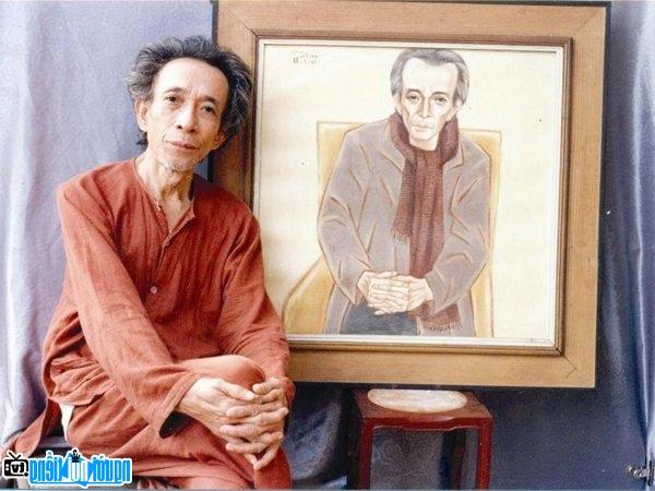 Nhà văn Kim Lân bên bức chân dung ông do họa sĩ Nguyễn Thị Hiền vẽ