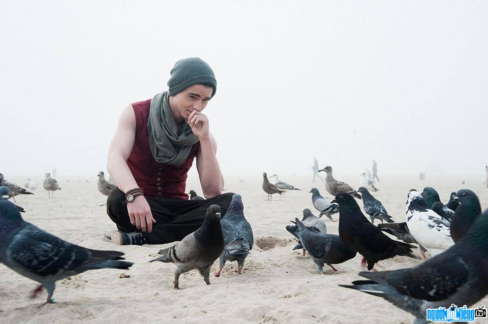 Bức ảnh nam diễn viên Callan McAuliffe đang tạo dáng cùng bầy chim