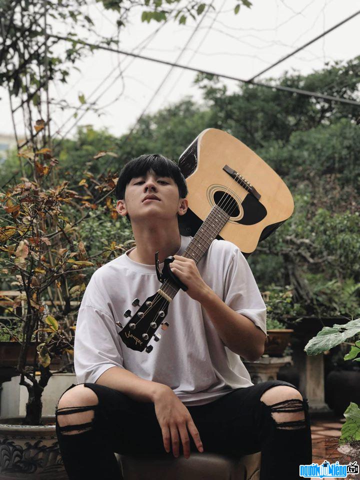 Nguyễn Tiến Hưng điển trai bên cây đàn guitar