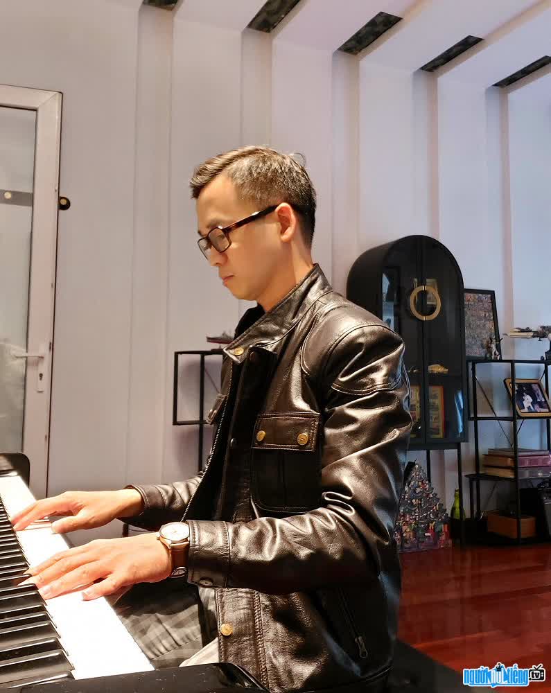 Hình ảnh nhạc sĩ Tuấn Nguyễn bên cây đàn