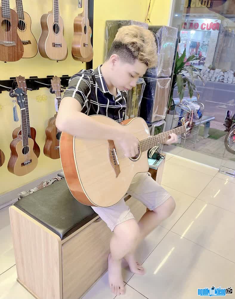Hình ảnh Nguyễn Văn Sỹ bên cây đàn guitar