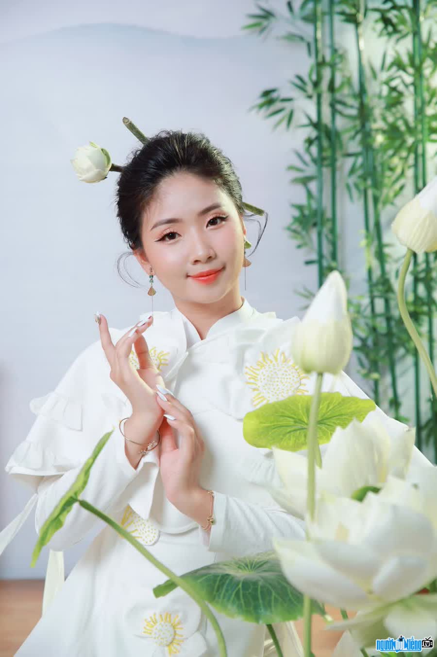 Image of singer Mai Thu Huong competing with lotus flowers