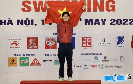 Image of swimmer Tran Hung Nguyen on podium receiving gold medal at SEA Games 32