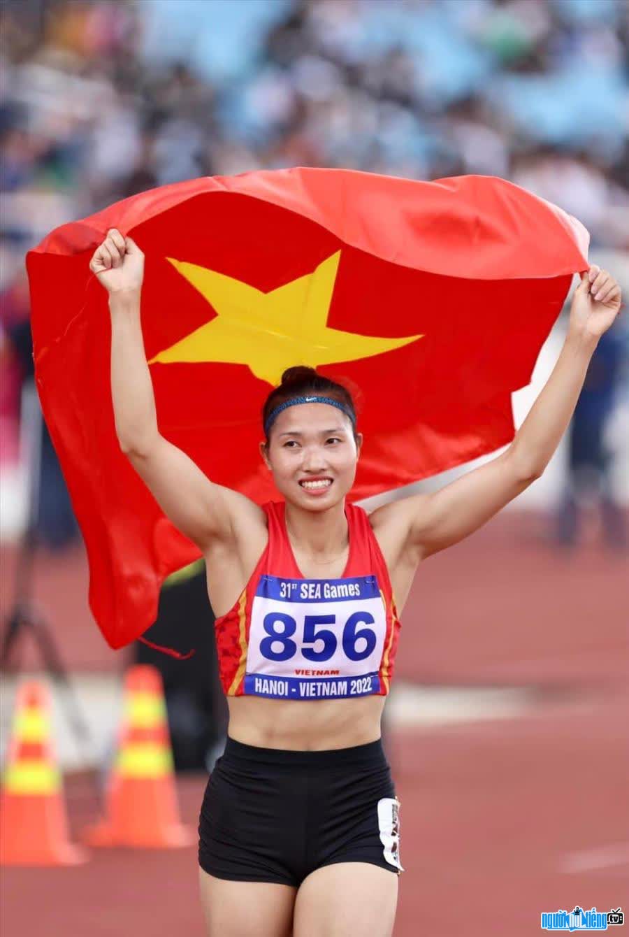 Hình ảnh vđv Nguyễn Linh Na giương cao lá quốc kỳ Việt Nam tại một đại hội thể thao
