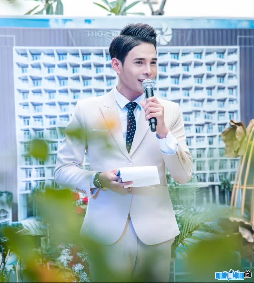  a picture of a handsome and confident Mai Thanh Huy when holding a mic