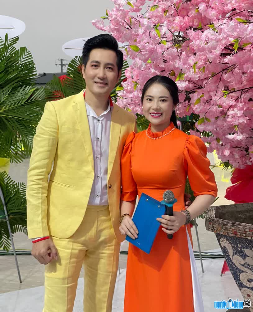 MC Minh Thy takes pictures with male singer Nguyen Phi Hung