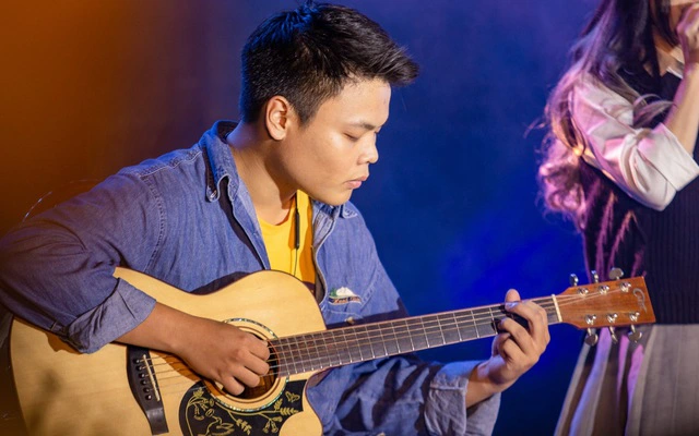 Hình ảnh nhạc sĩ Minh Cà Ri đang chơi đàn ghi ta