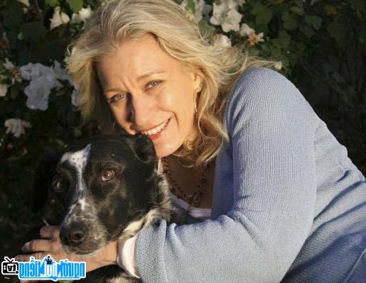 A photo of actress Diane Gaidry posing with her pet dog