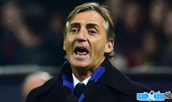 A photo of Roberto Mancini football coach pointing Coaching his students on the pitch
