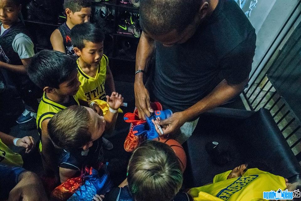 Image of Kevin Durant basketball player signing autographs Young fan
