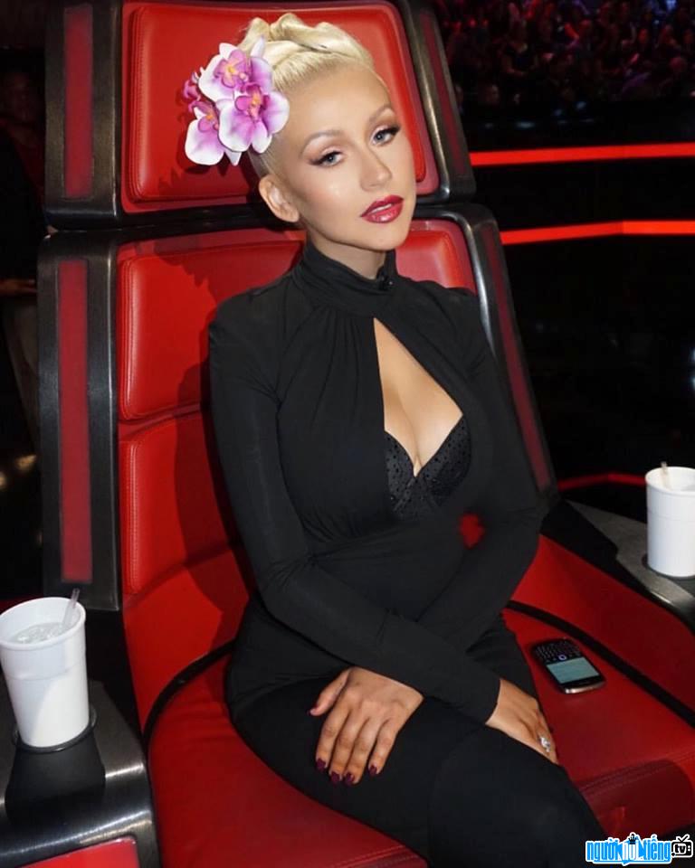 Picture of female singer Christina Aguilera sitting on the coach of The Voice America