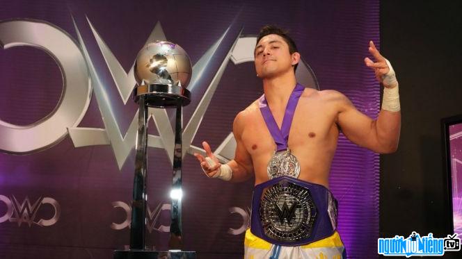 Image of wrestler TJ Perkins and the championship trophy