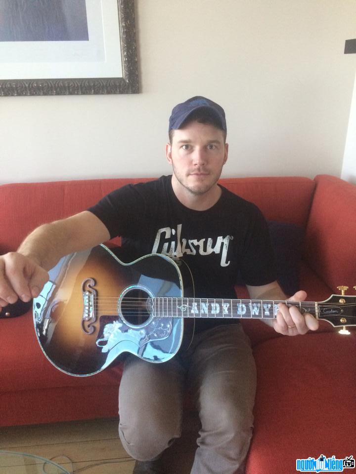 Photo of movie star Chris Pratt playing guitar