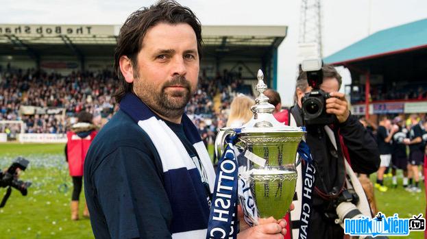 Picture of Paul Hartley receiving the trophy