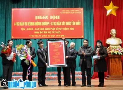 Poet Ma The Vinh received souvenirs from the Vietnam Association of Culture and Arts of Ethnic Minorities.