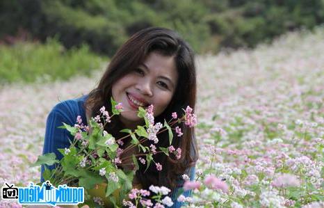  Young writer Nhu Binh beside flowers