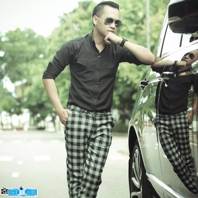 Singer Hoang Nhat Minh posing next to a supercar