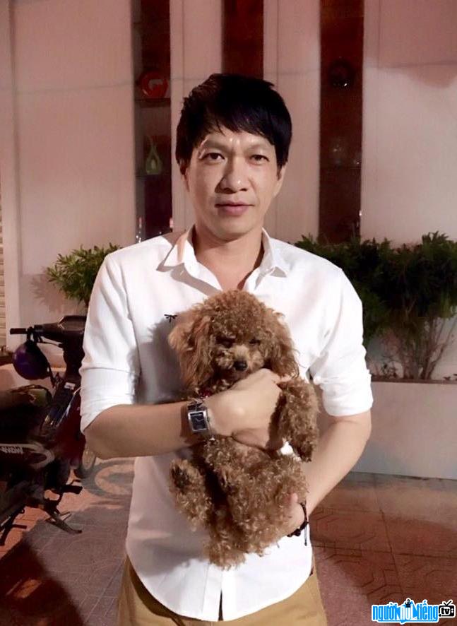 Picture of singer Nguyen Minh Anh holding his pet dog