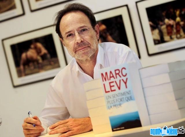 The picture of novelist Marc Levy signing autographs for fans