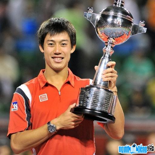 Picture of tennis player Nishikori Kei holding up her championship trophy