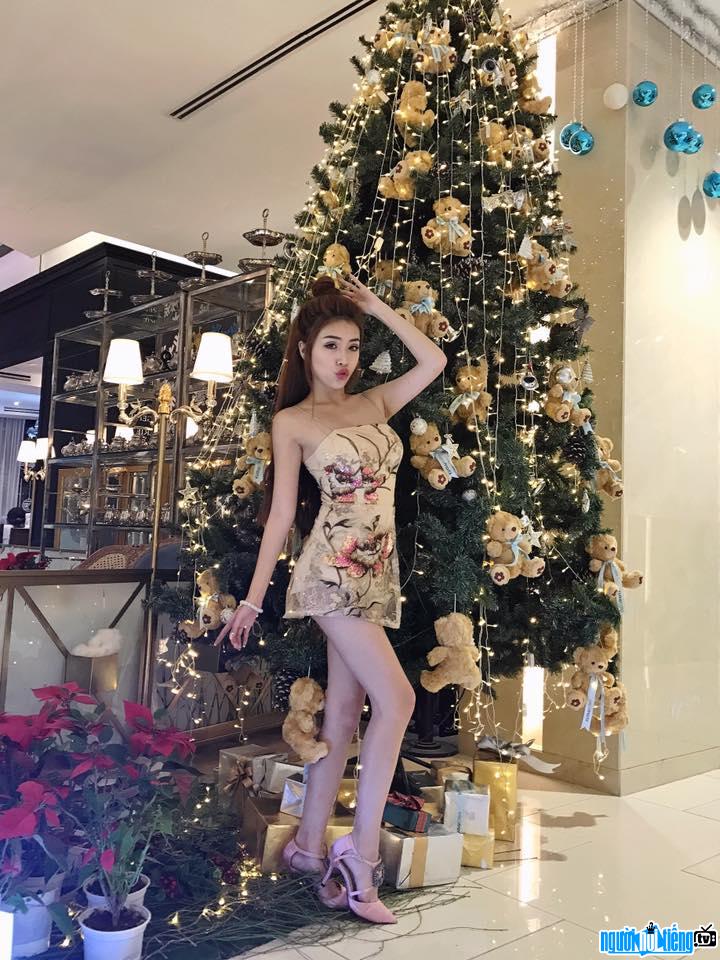A photo of actress Pinky Bao Tran showing off her figure by the Christmas tree