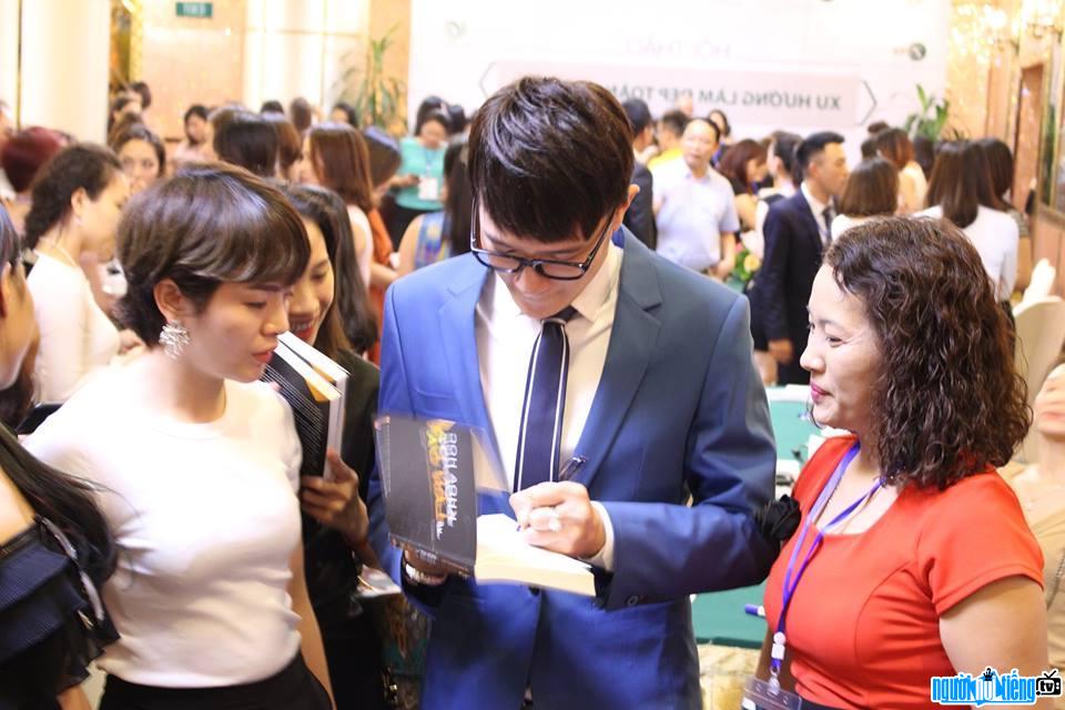 Bức ảnh nam vương Tiến Phạm đang ký tặng fan