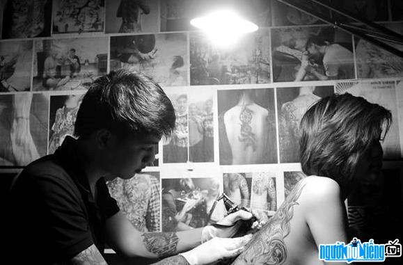  Tattoo artist Dao Duc Hieu is tattooing a female customer