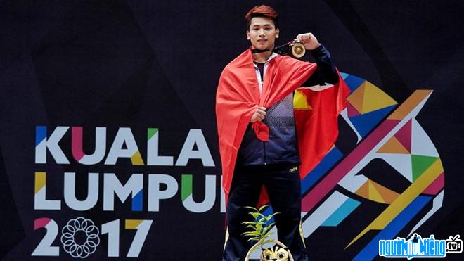 Image of weightlifting athlete Trinh Van Vinh on the podium receiving awards
